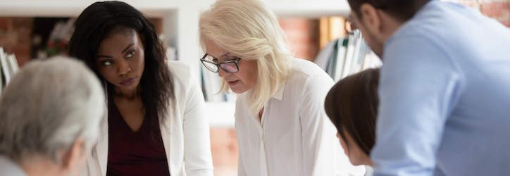 Business woman supervisor teaching workers at group meeting